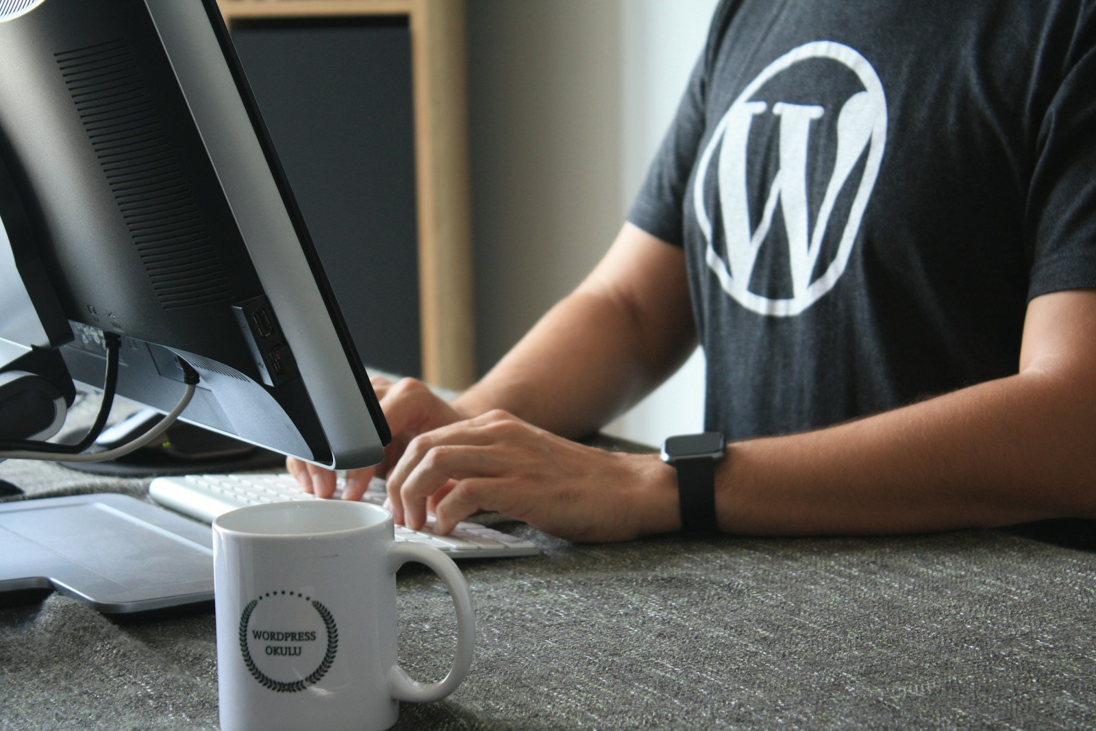 Photo by Fikret tozak person in black and white t-shirt using computer